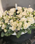 Bouquet of white flowers with a bottle of champagne on a black surface, with 'GRAVEL' branding in the background.