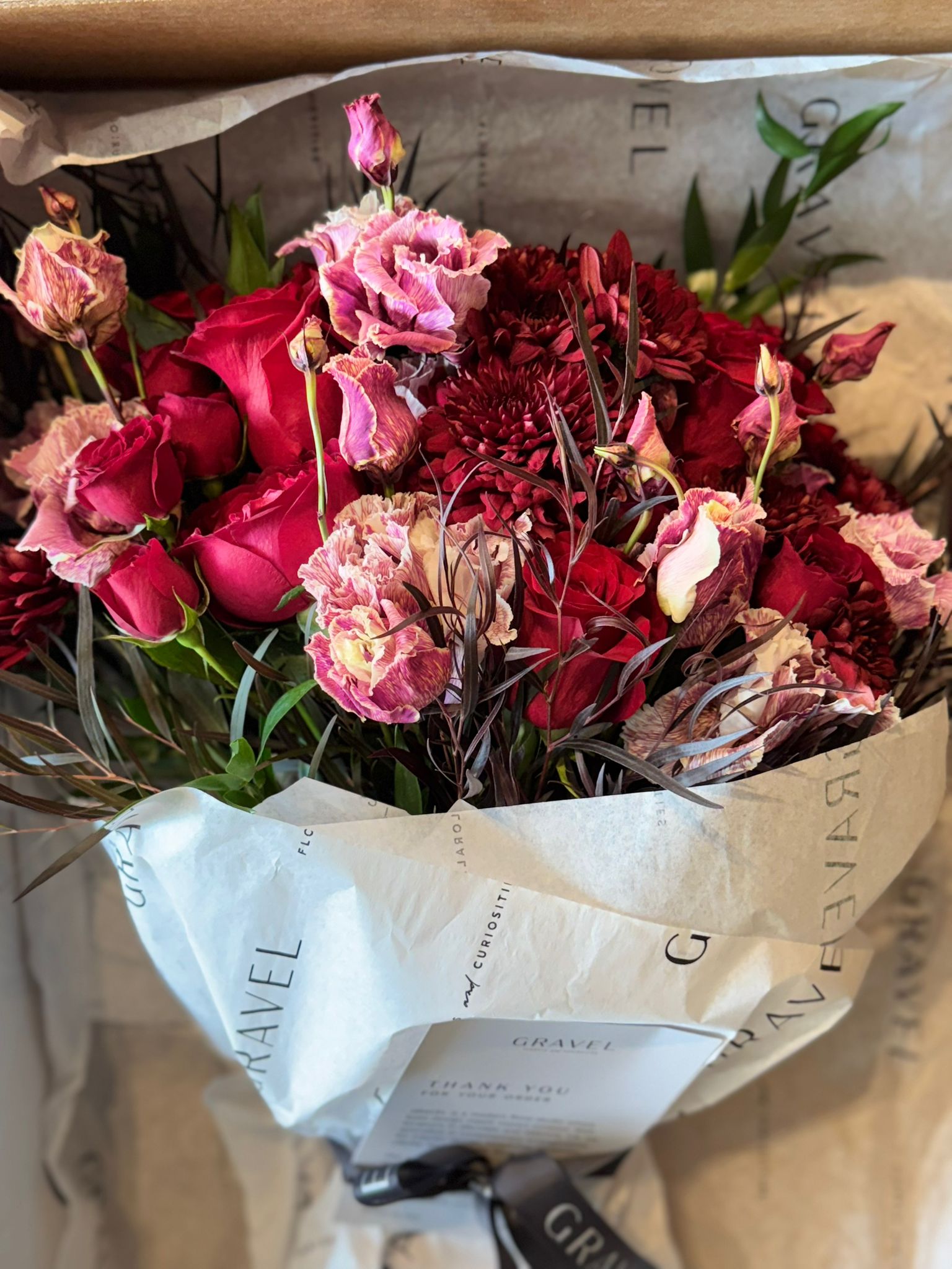 Red Roses, Lisianthus, Red Chrysanthemums, Agonis, and Italian Ruscus Hand Bouquet