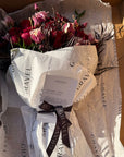 Red Roses, Lisianthus, Red Chrysanthemums, Agonis, and Italian Ruscus Hand Bouquet