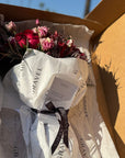 Red Roses, Lisianthus, Red Chrysanthemums, Agonis, and Italian Ruscus Hand Bouquet