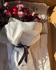 Red Roses, Lisianthus, Red Chrysanthemums, Agonis, and Italian Ruscus Hand Bouquet