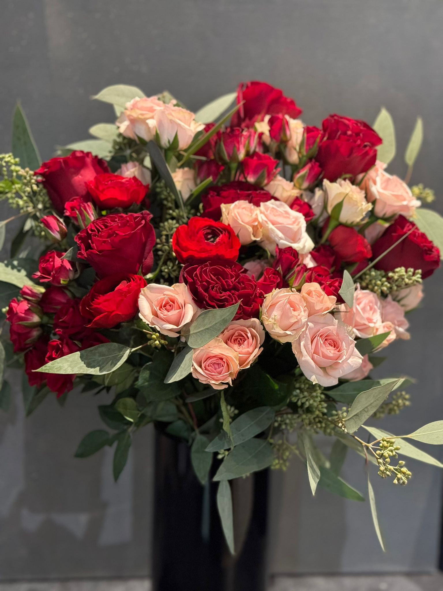 Red and Pink Roses, Ranunculus, and Eucalyptus Bouquet 